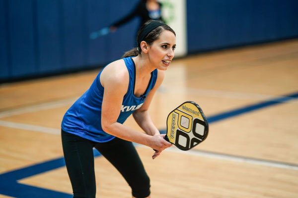 A KVUE reporter holds a pickleball racquet in the gym.