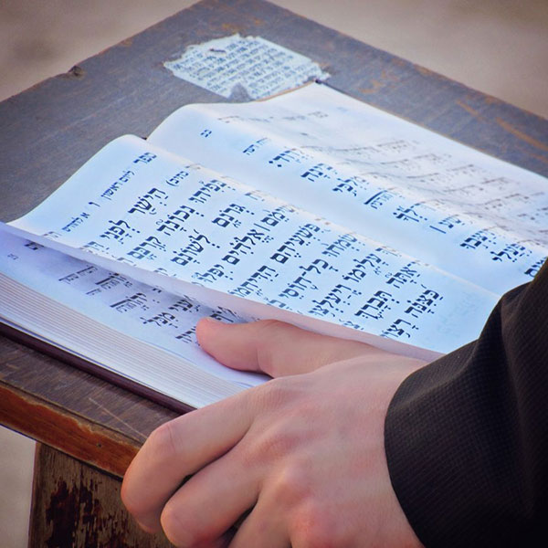A man reading from a prayer book during a service at a synagogue