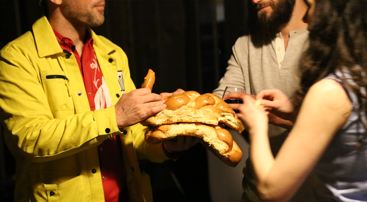 People enjoy challah bread during a SXSW Shabbat at Moishe House