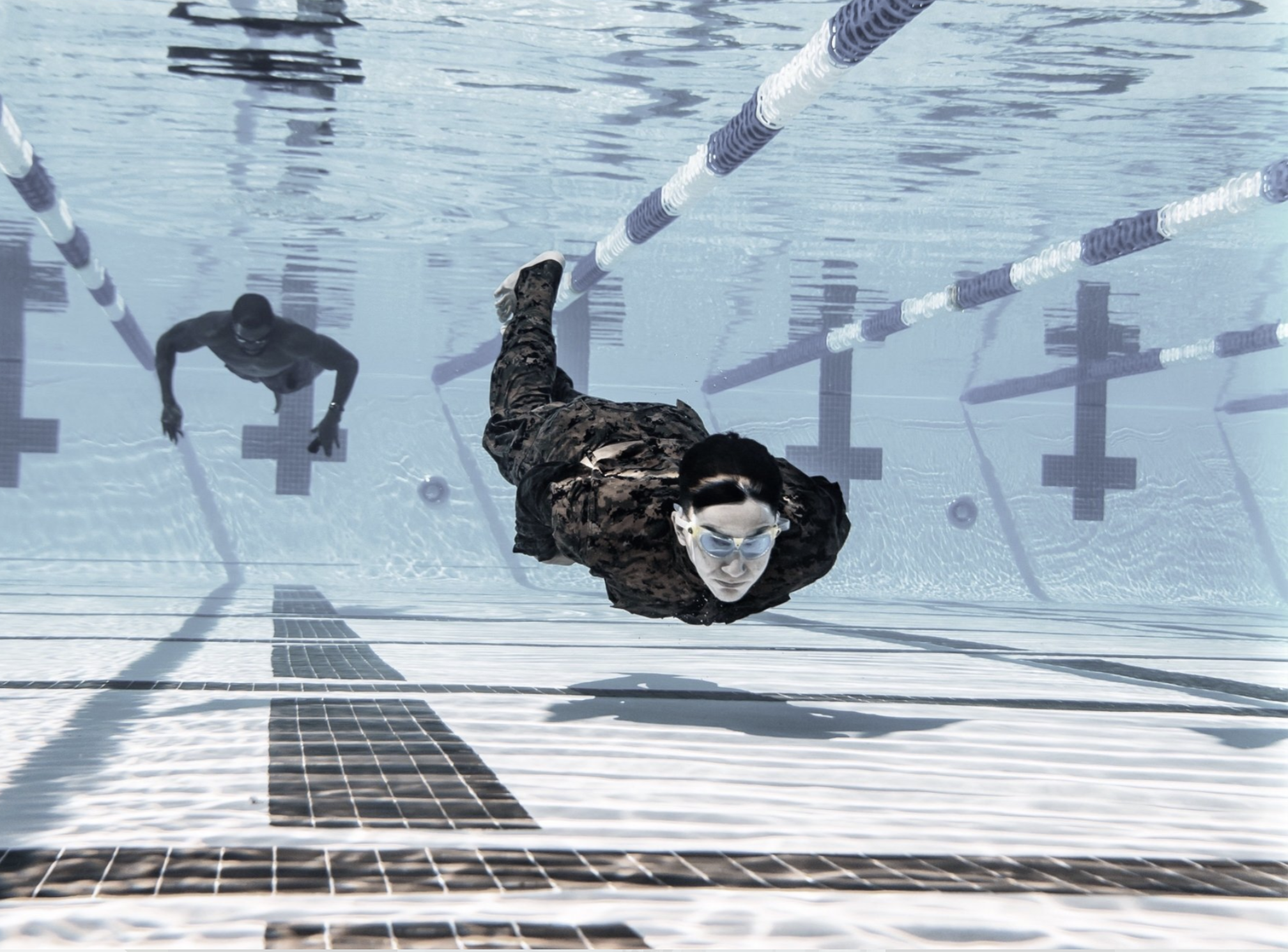 Overhead view of man wearing a swim cap doing a butterfly stroke in the pool.