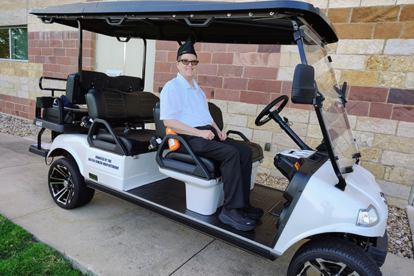 Denise Breard, a patron member of the Austin Jewish War Veterans Post 757, sits in the golf cart donated by Jewish War Veterans Post 757 to the Austin Veterans Administration. Credit: Cynthia Baihlah Rubin